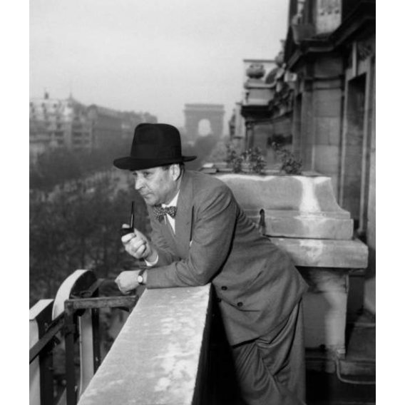 L'écrivain français Georges Simenon (1903-1989) fumant la pipe sur un balcon de l'hôtel Claridge